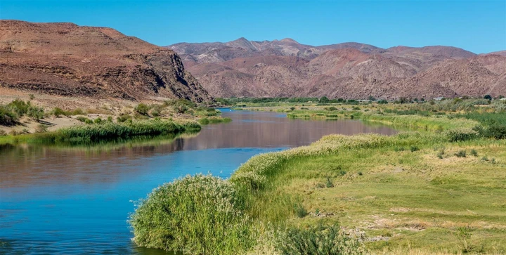 Les berges verdoyantes du fleuve contrastent avec le désert lunaire environnant