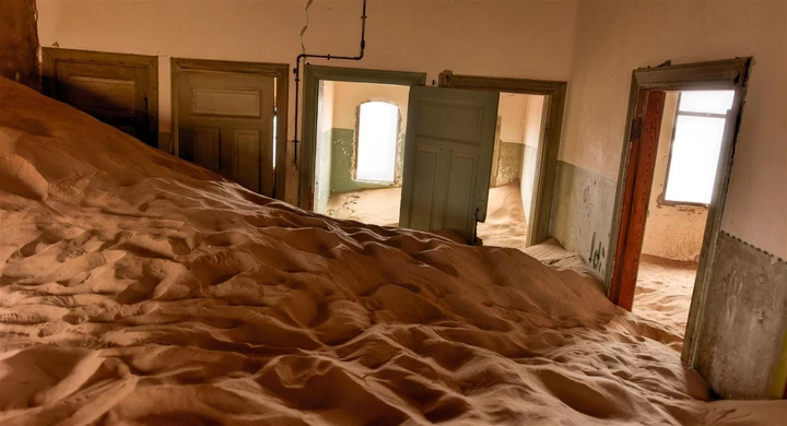 Pièce envahie par le sable dans la ville fantôme